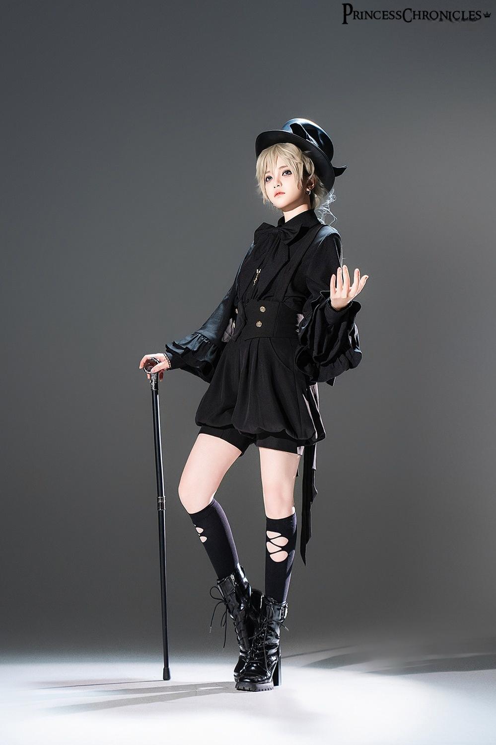 Front portrait of black Ouji Lolita coordinate with detachable bow tie shirt, corset-style waist panel, cross pendant accessory, top hat, and gothic aristocratic styling