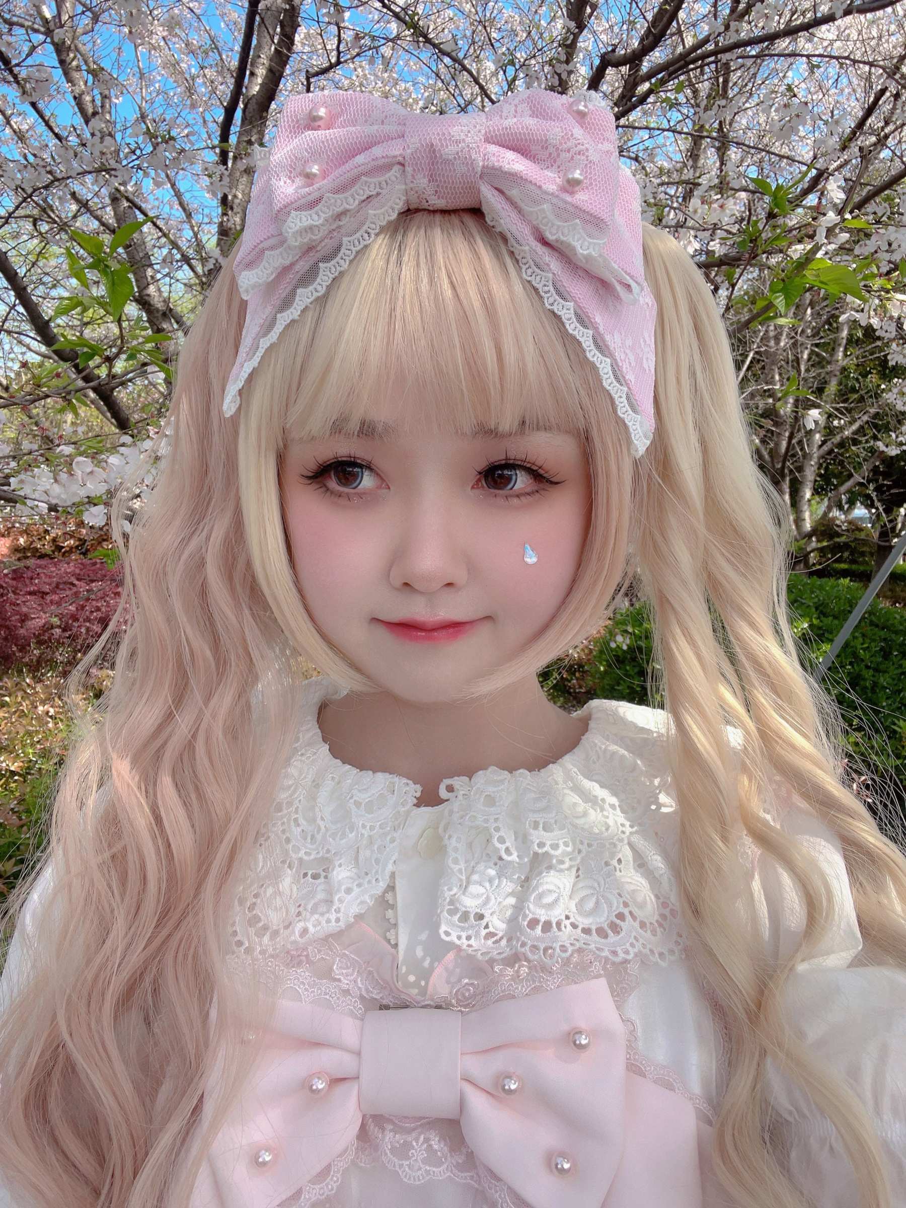 Satin light pink sweet lolita pearl bow KC headband worn on real model with light pink twin hair white lace dress cherry blossom park outdoor