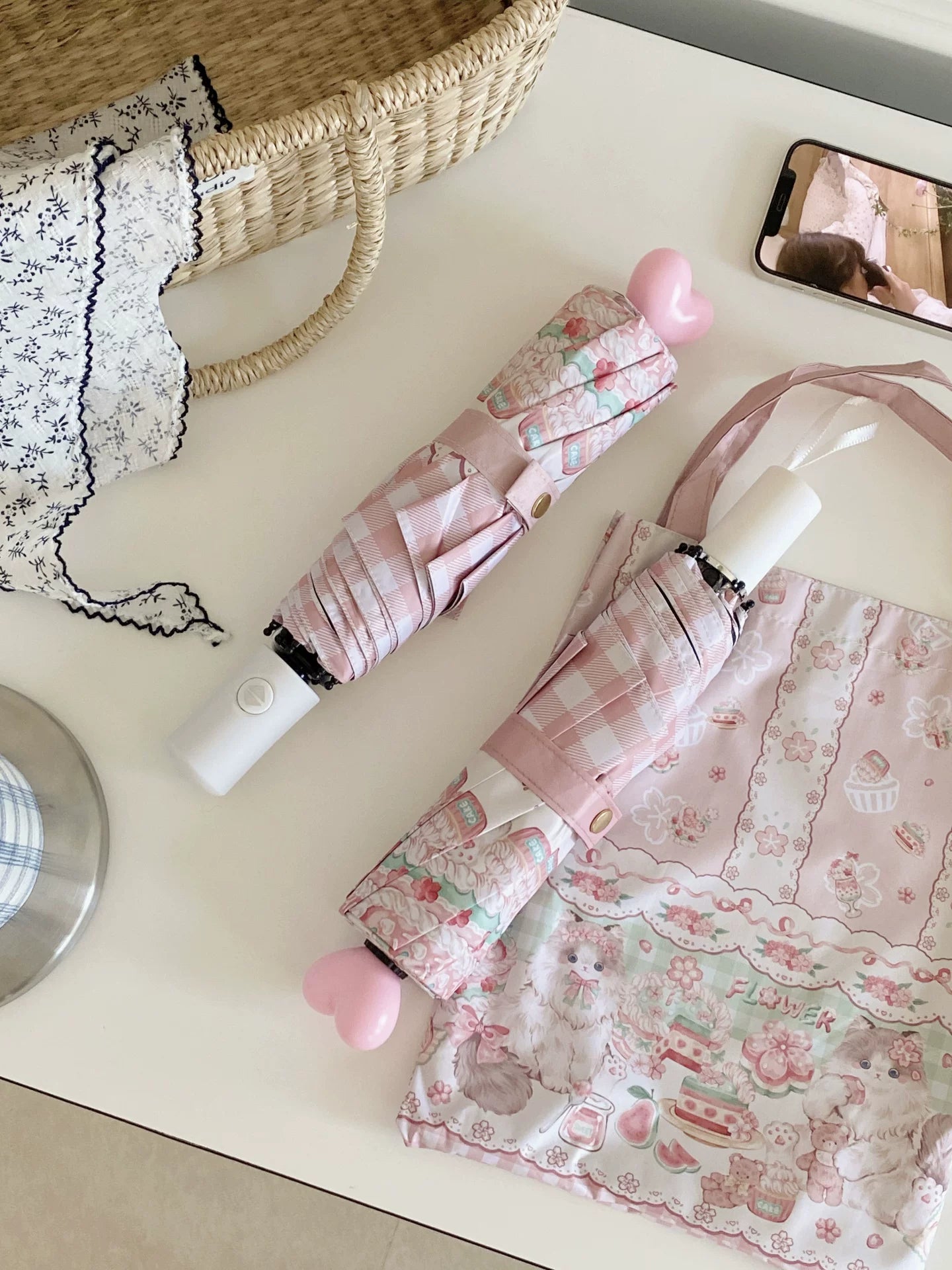 Close-up detail of pink checkered lolita parasol with cute cartoon prints floral design and automatic handle mechanism
