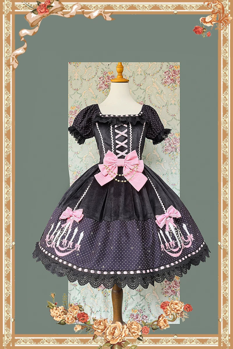 Classic black and pink sweet lolita OP dress with two small pink decorative bows and chandelier prints on polka dot fabric displayed against vintage floral backdrop