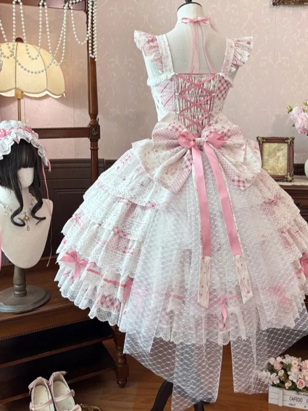 Back mannequin display of pink floral lolita JSK with polka dot sheer tulle overskirt, detachable back bow, and coordinating accessories on vintage studio backdrop