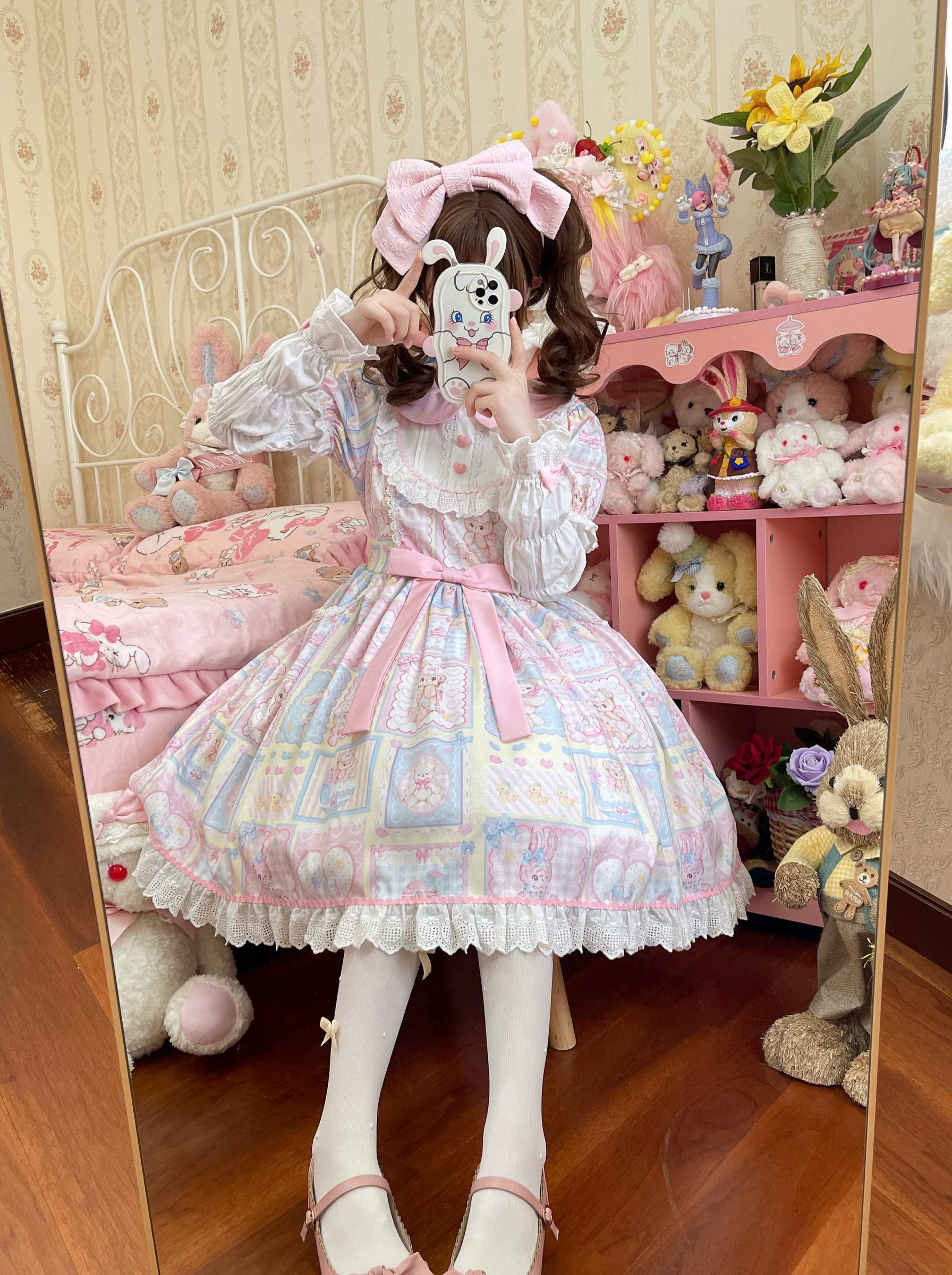 Mirror front close-up shot of Sweet Bunny Bear Lolita OP dress with white ruffled tights, ruffled chest details, pink waist sash, bunny phone case styling in plush toy bedroom theme