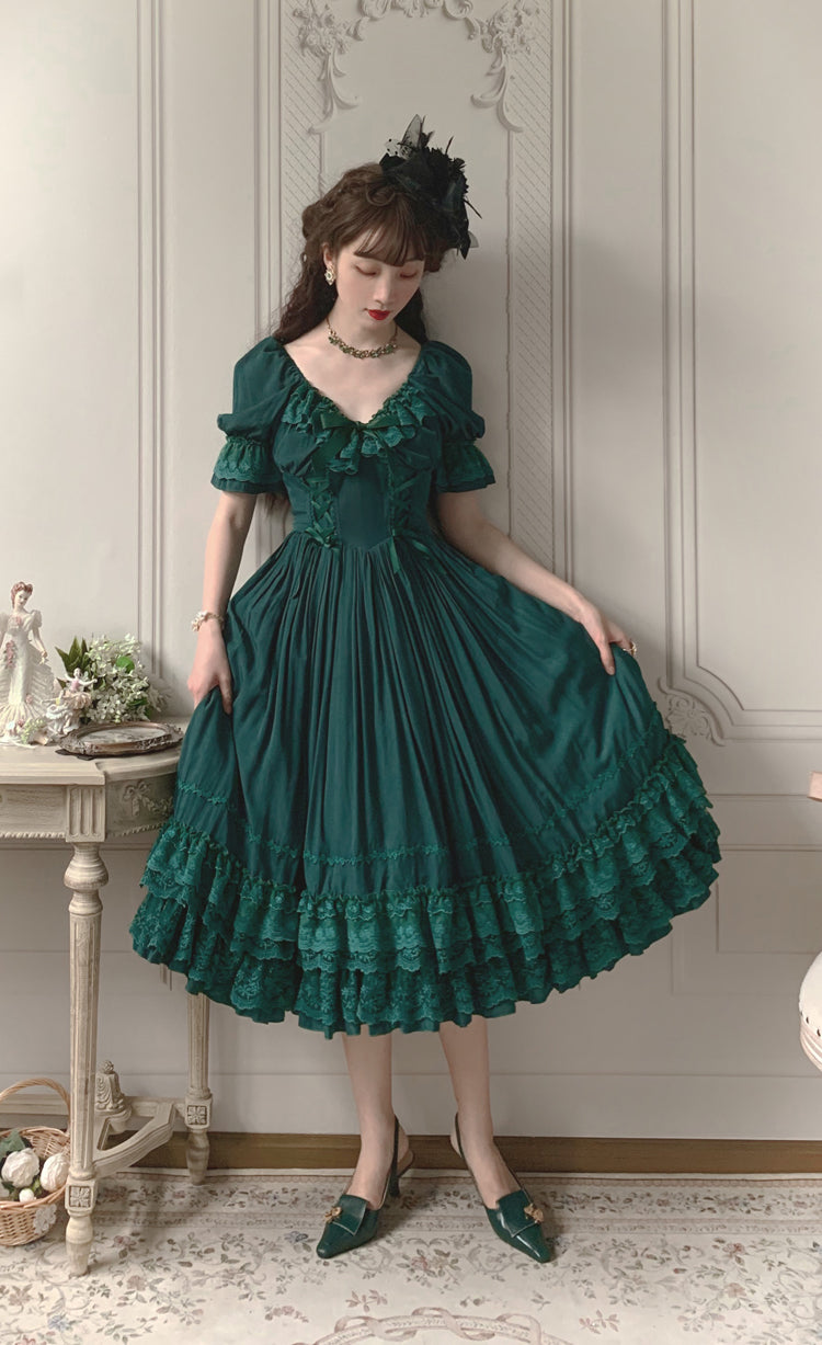 Dark green French Lolita OP dress with matte satin fabric, puff sleeves and pleated skirt, half-side view with matching green heels in vintage living room