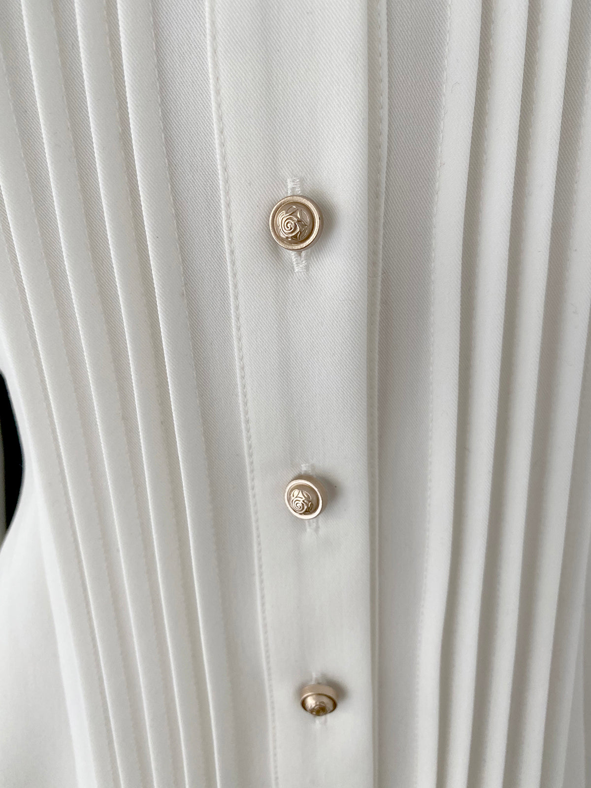 Close-up front placket vertical pleats round metal decorative buttons white Lolita blouse fabric texture detail