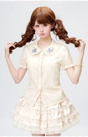 Kawaii lolita girl wearing cream Peter Pan collar embroidered blouse with puff sleeves styled with ruffled lace skirt and twin curly buns in vintage tea room setting