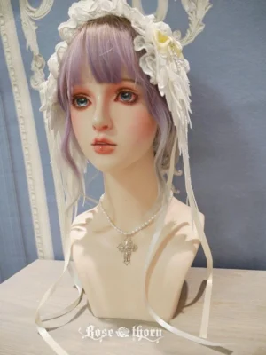 Celestial angel wings embroidered lace lolita headdress front view on mannequin with purple wig, white embroidered wings with satin ribbons and cross pendant, vintage European interior background