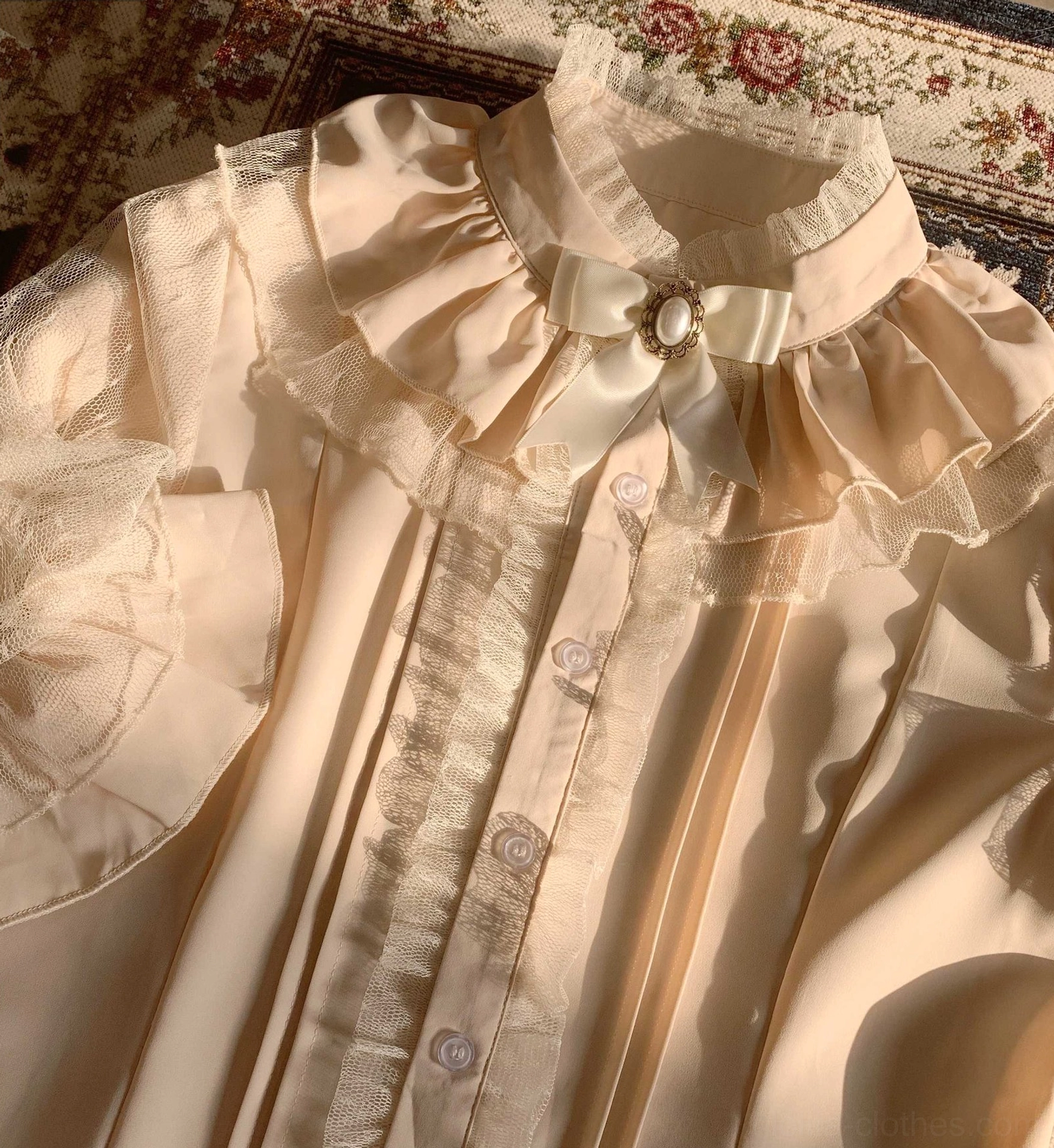 Apricot beige lolita inner blouse close-up top down view layered ruffled stand collar satin bow gem brooch front button placket