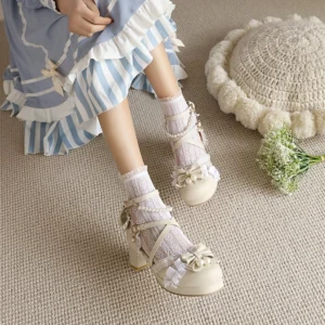 Apricot beige Qi Lolita Mary Jane heels with lace butterfly bows and pearl accents shown from overhead angle worn with blue striped ruffled Lolita dress and matching lace ankle socks