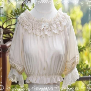 Apricot lightweight chiffon Lolita inner blouse featuring lace ruffled neck with detachable satin bow and elasticated ruffled hem on dress form outdoor backyard background