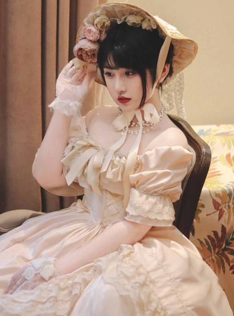 Cream apricot French Lolita OP dress with off-shoulder puff sleeves, bow tie collar and multi-layer lace ruffles, full front view in European vintage door setting