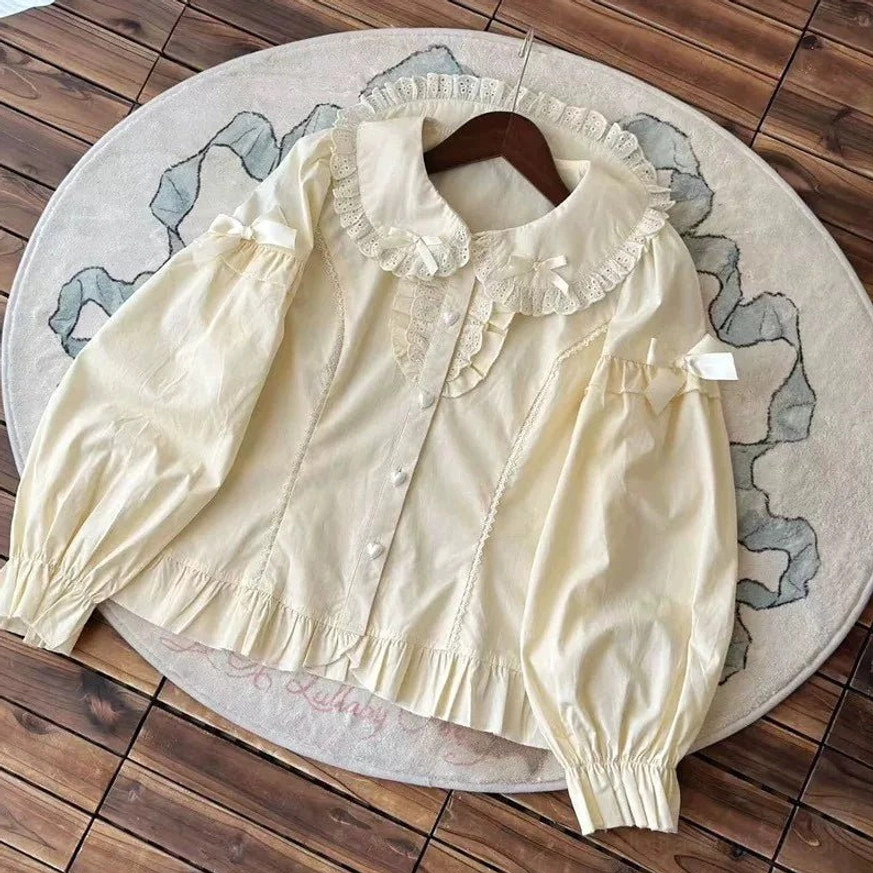 Long sleeve apricot beige lolita peter pan collar blouse puff sleeves lace ruffled collar hem shoulder bow detail flat lay wooden hanger