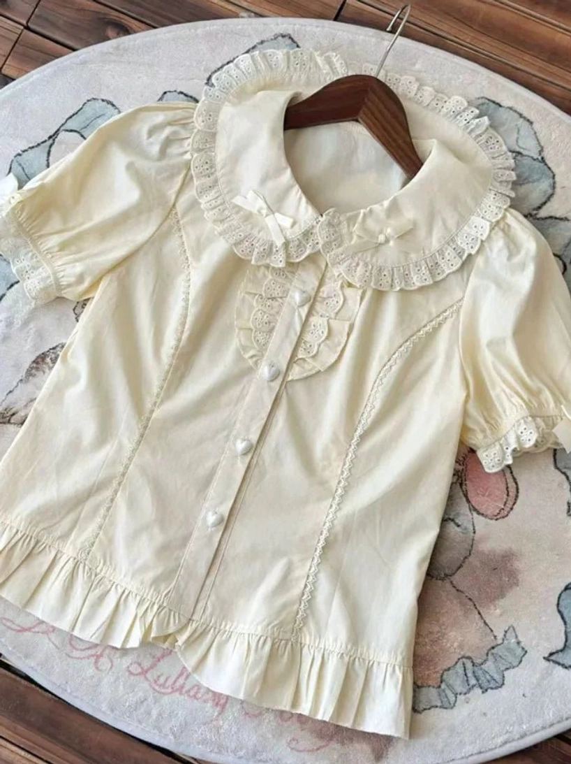 Short sleeve apricot lolita peter pan collar blouse lace ruffled collar puff sleeves decorative bow detail flat lay rug display