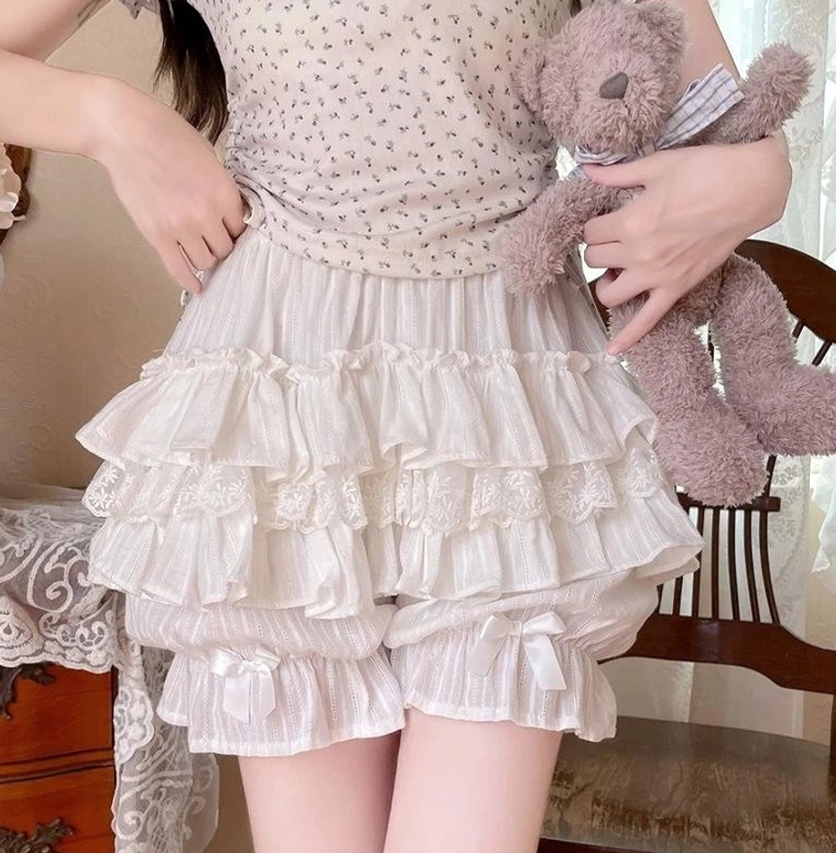 Light apricot pink sweet lolita cotton bloomers side view worn by model holding teddy bear vintage dining room setting tiered ruffles lace trim satin bows