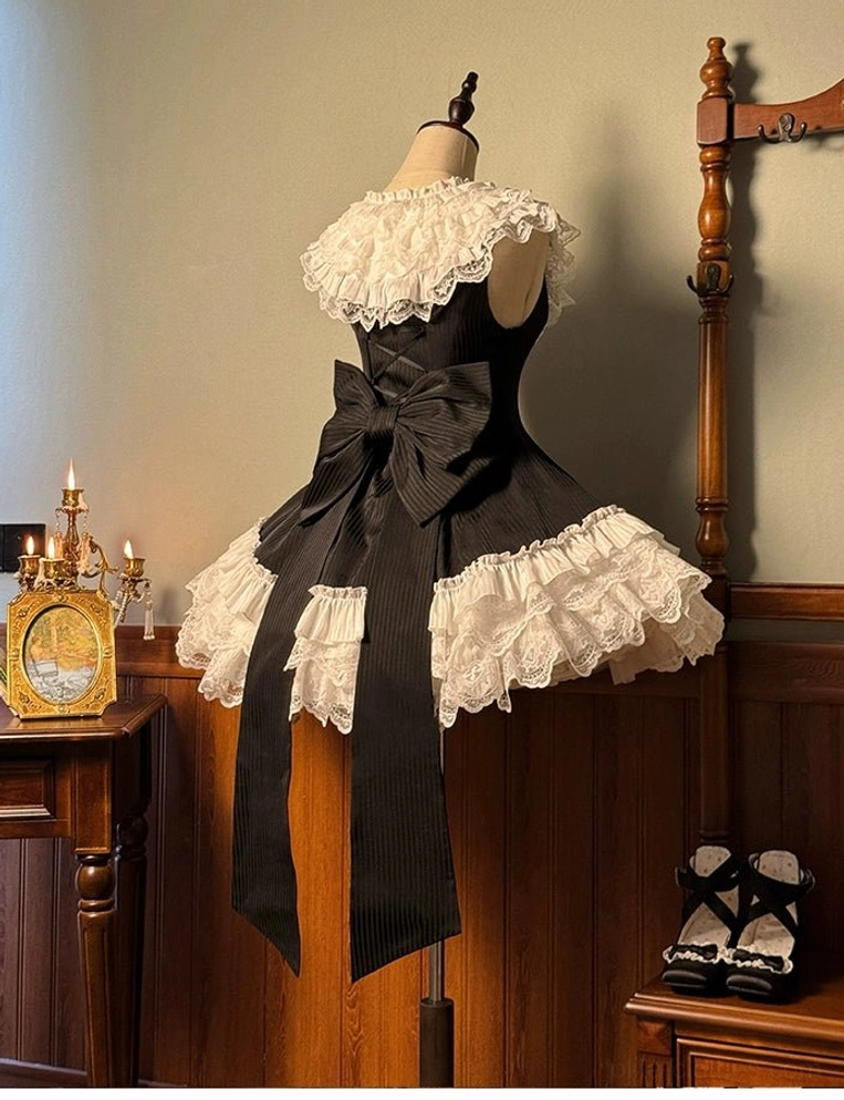 Black sweet lolita dress with white ruffled lace details and extended back bow trailing ribbons display
