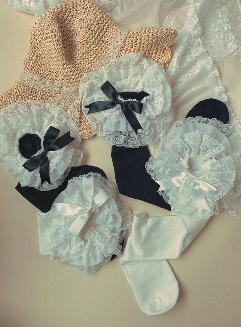 Assorted Lolita lace trim bow socks flat lay overhead view black and white styles with multiple lace bow decorations straw hat background