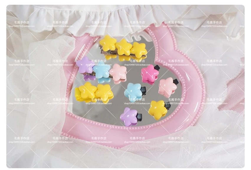 Full assorted set of multicolor star-shaped hair clips showing complete color range for sweet lolita styling on vanity mirror