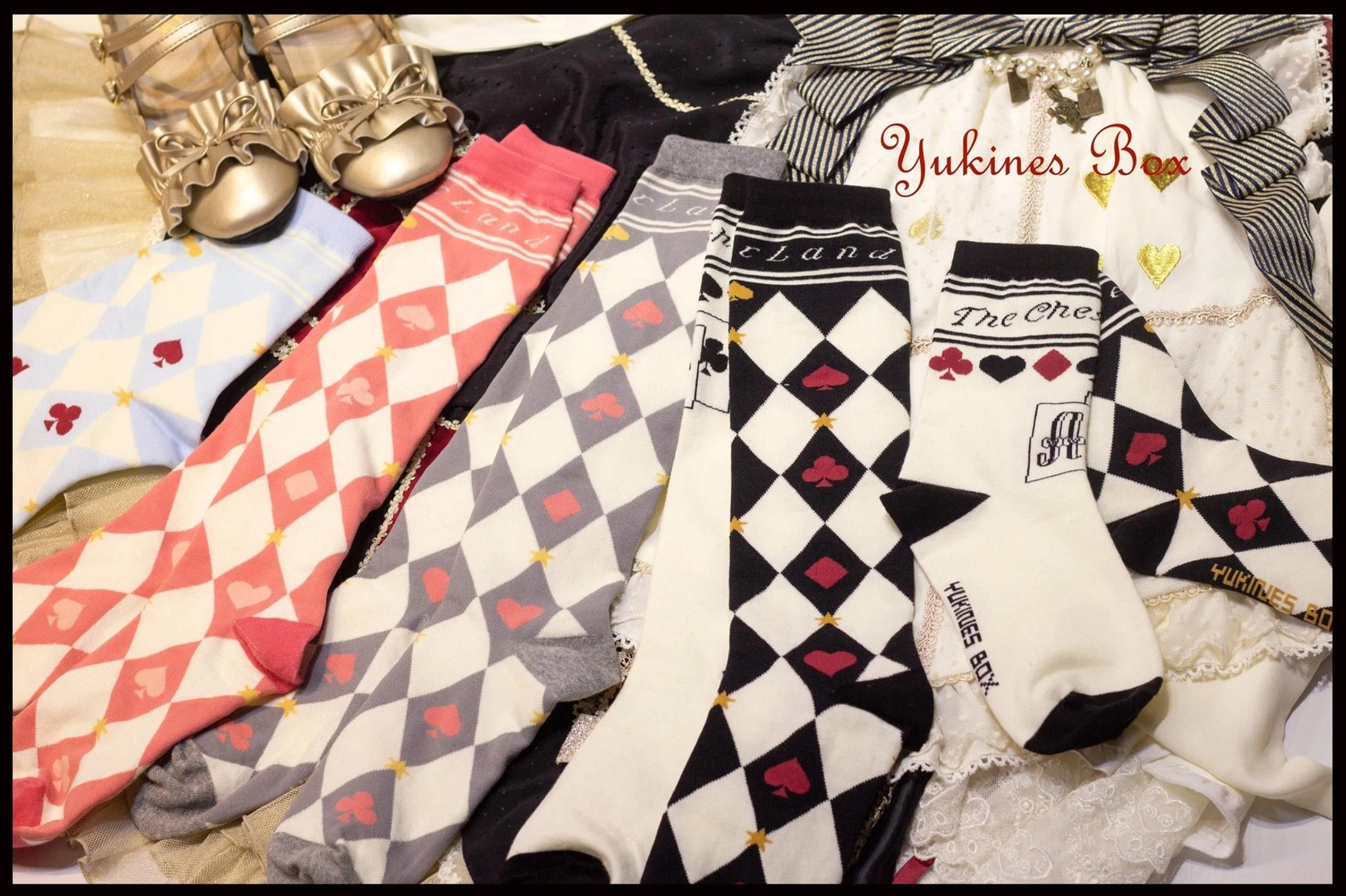 Multiple asymmetrical print lolita cotton socks flat lay display wooden desk with classic Alice tea party shoes and decorative hair bows