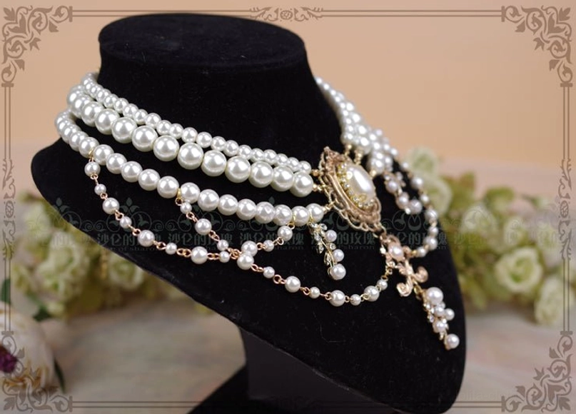 Three-quarter side view of baroque pearl layered choker necklace displaying chain layers mixed pearl sizes and side filigree charms