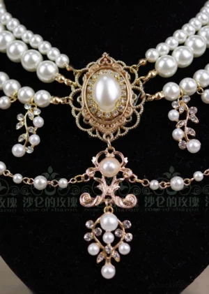 Overhead close-up view of baroque pearl necklace showing full layered design central oval pearl and gold filigree details from above