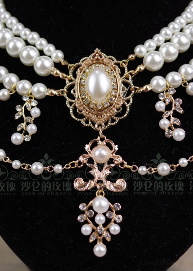 Overhead close-up view of baroque pearl necklace showing full layered design central oval pearl and gold filigree details from above