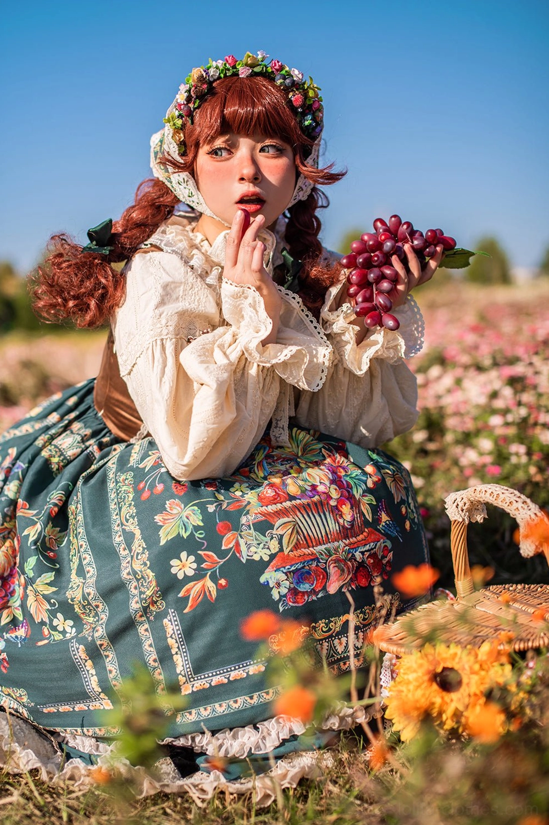 Bavarian Lolita JSK squatting pose displaying petal skirt layers bonnet and flower field aesthetic