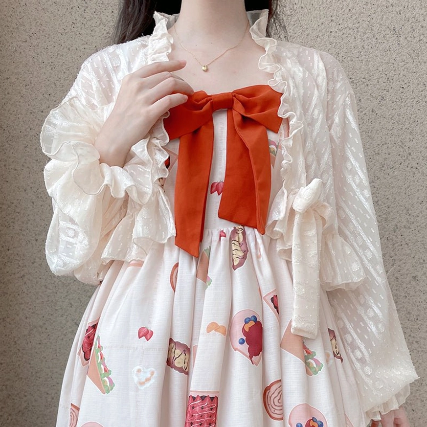 Beige apricot chiffon puff sleeve sweet Lolita cardigan with side bow detail worn on model layered over printed dress