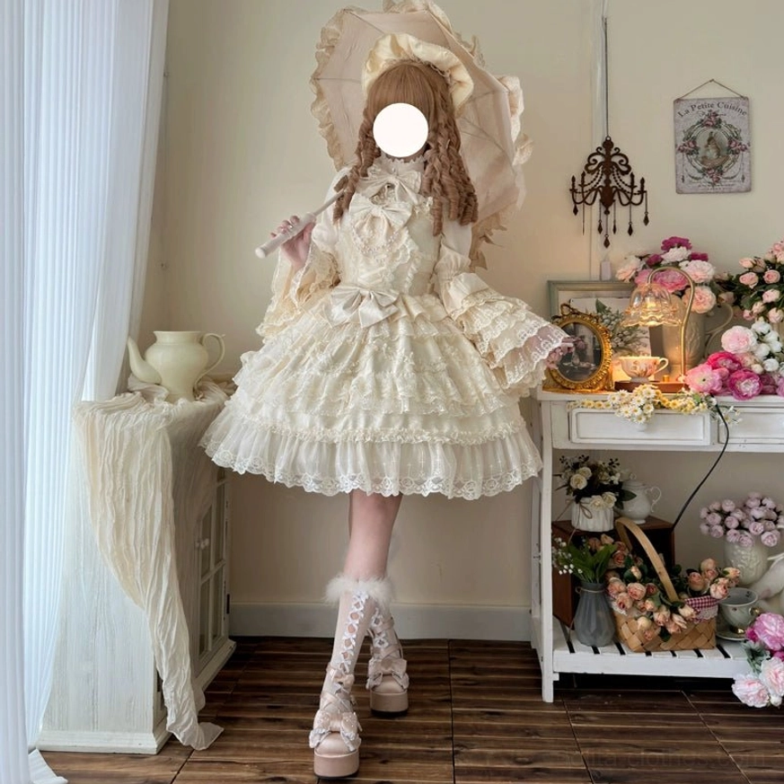 Beige cream sweet wedding lolita JSK dress with matching bonnet full-body front standing view showing all-over lace texture and ruffled sleeves