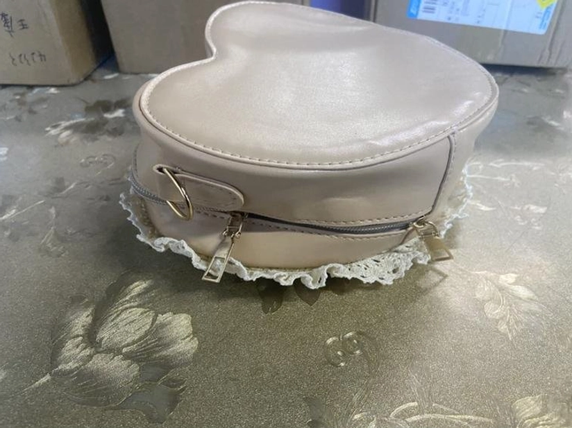Beige heart-shaped Lolita crossbody bag variation with smooth PU leather finish detachable strap zipper and lace bottom trim