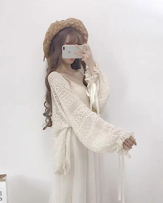 Left side mirror selfie highlighting beige hollow crochet cardigan sleeve detail with satin ribbon tie lantern sleeves and relaxed loose fit