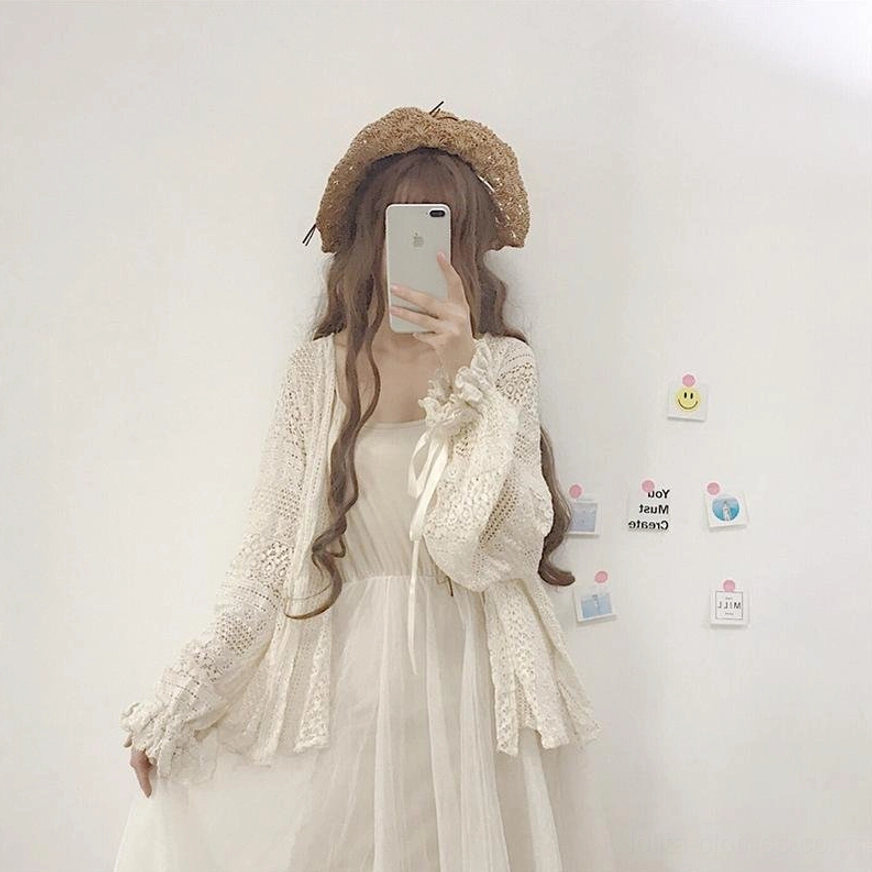 Beige hollow crochet lolita cardigan texture and construction detail shot highlighting crocheted fabric and ribbon sleeve decoration for styling inspiration