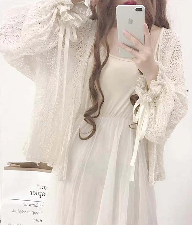 Beige hollow crochet oversized cardigan front close-up focusing on lantern sleeves with satin ribbon and loose knitted fabric texture details