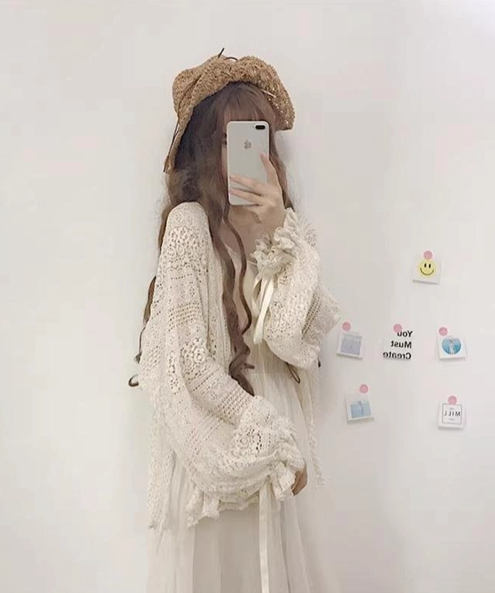 Beige hollow knit lolita cardigan back detail view with crocheted hollow sleeves and ribbon-decorated cuffs in oversized loose fit silhouette