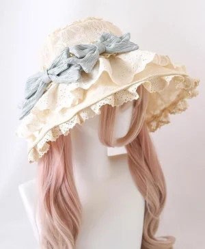 Beige lace Lolita sun hat with light blue detachable bows, three-quarter front view showing intricate ruffled eyelet lace brim and shapeable wire design