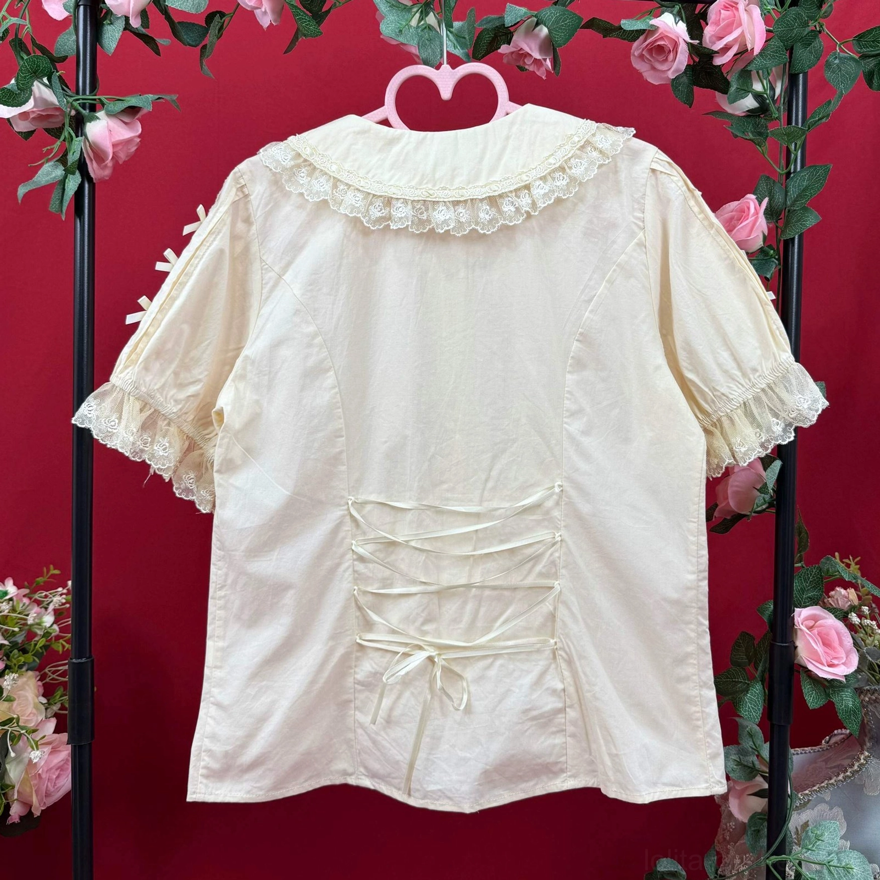 Back view beige lolita cotton blouse showing lace peter pan collar ruffled sleeves and crisscross drawstring waist