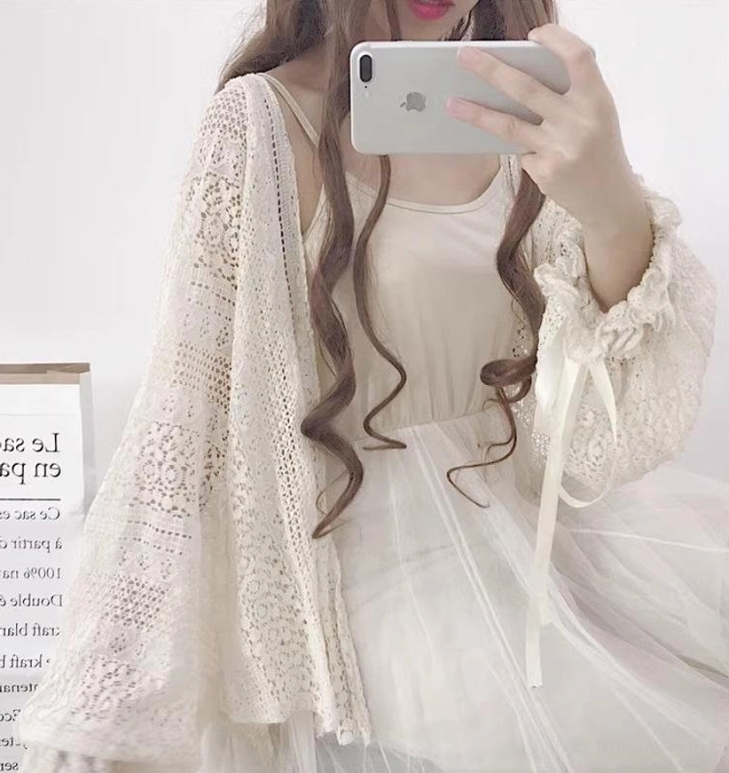 Beige oversized lolita crochet cardigan close-up upper body detail showing hollow knit construction and ribbon-decorated lantern sleeve cuffs