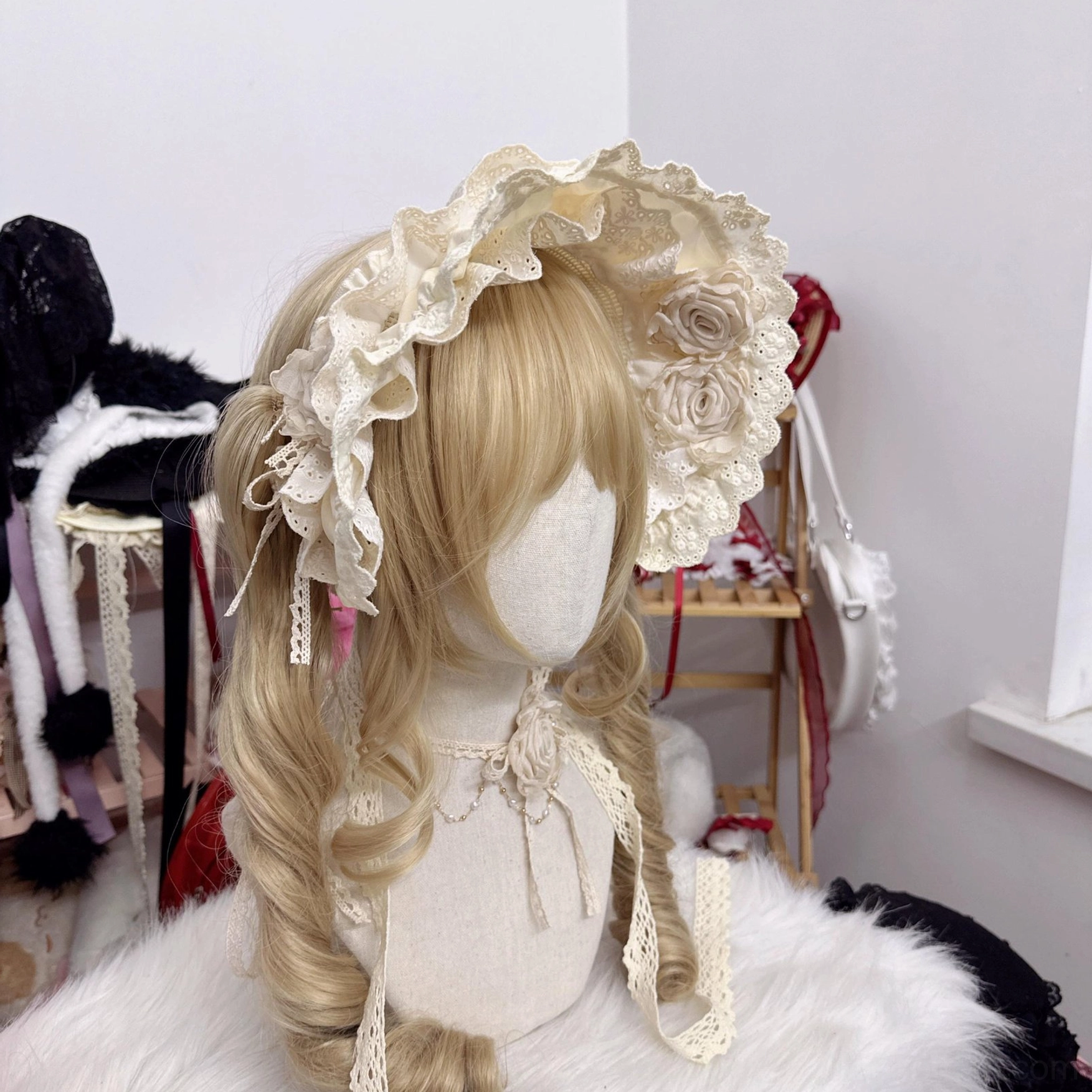 beige lolita bonnet with delicate lace tassel details on straps and fabric rose ornaments front angle