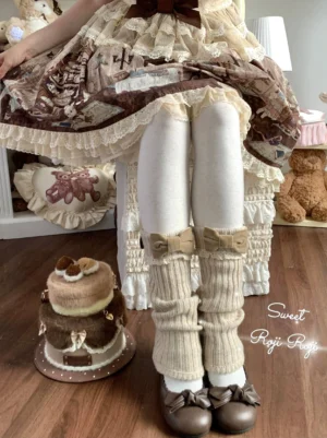 Creamy beige velvet bow flared-hem Lolita leg warmers with yellow-brown bow worn with bear-print sweet Lolita dress, white tights and brown leather shoes on model's lower legs, showcasing vintage teddy bear and dessert styling