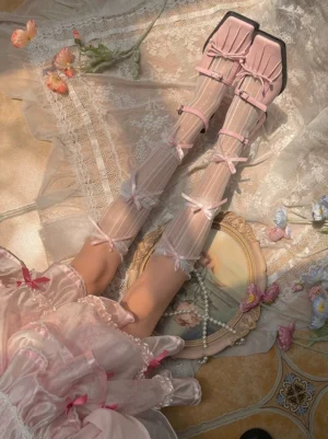 Beige lolita mid-calf sheer decorative socks with vertical striped mesh and delicate pink satin bow accents paired with ruffled lolita dress and matching mary janes overhead view