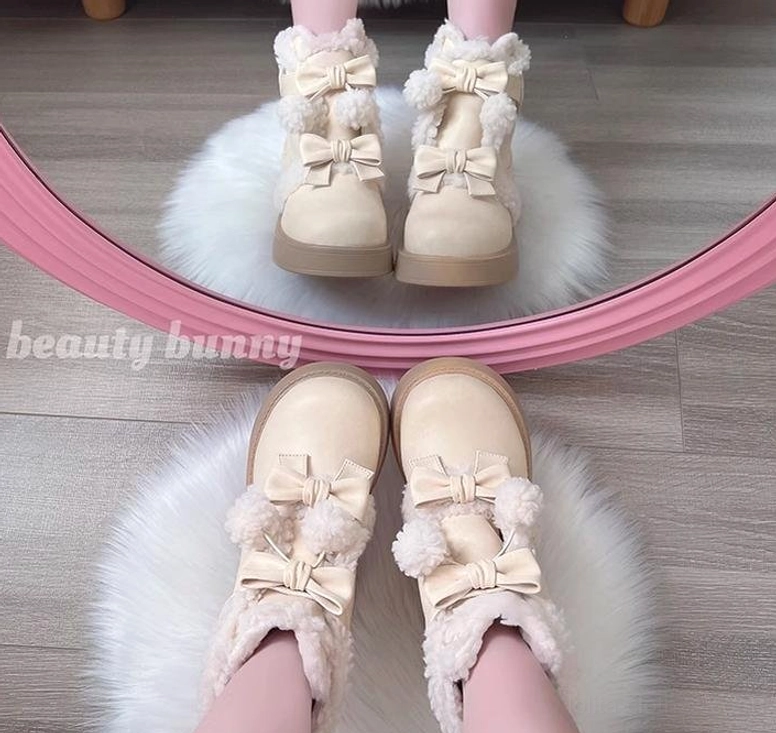Beige lolita winter snow boots overhead flat lay on wooden floor with fluffy fur rug bowknot accents shearling collar display