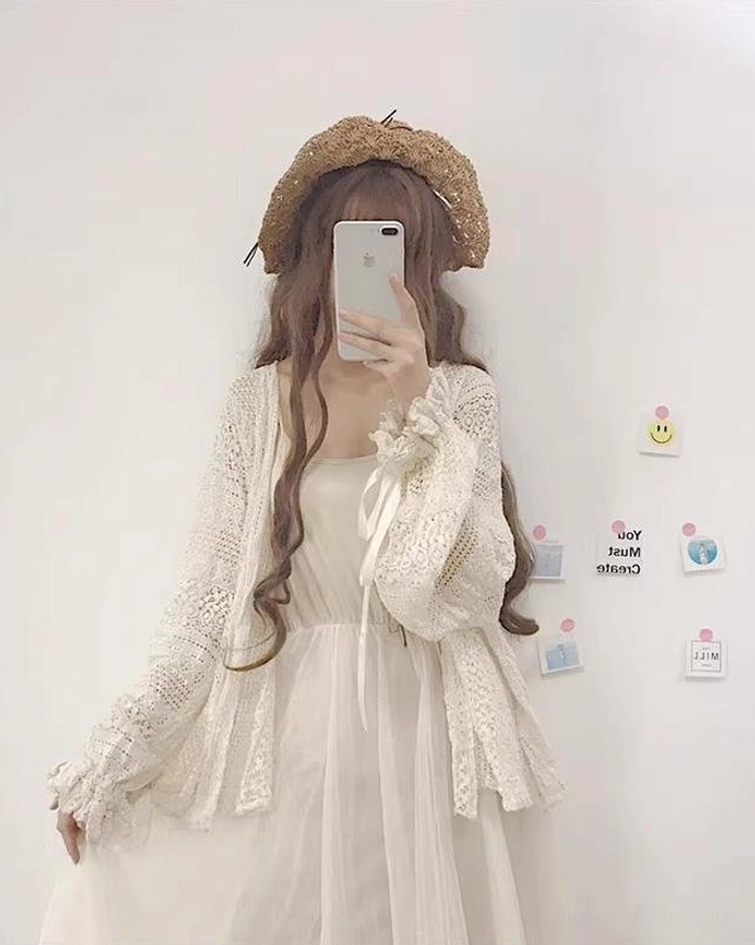 Front-facing view of beige oversized hollow crochet lolita cardigan with open front design and ribbon-tied cuffs, paired with tulle dress and straw hat