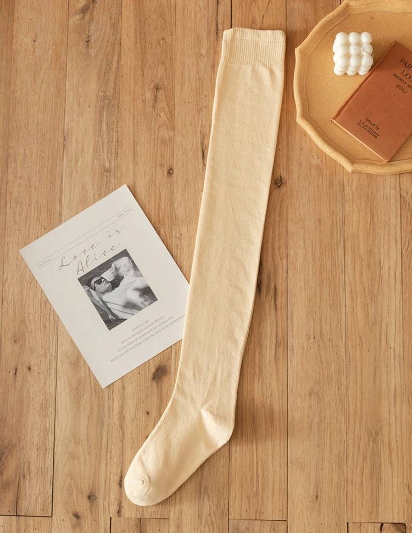 Single beige skin-tone lolita cotton knee stocking flat lay wooden table candle postcard warm color ribbed knit