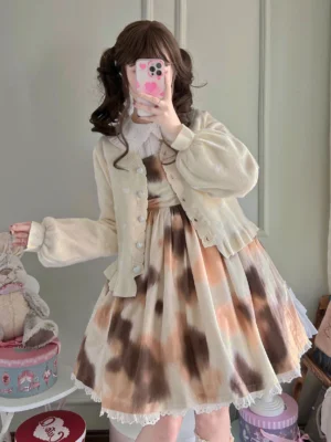 Apricot beige solid color loose lolita knitted cardigan with ruffled cuffs and hem worn by model with twin-tails hairstyle, paired with tie-dye leopard print lolita dress and V-neck styling