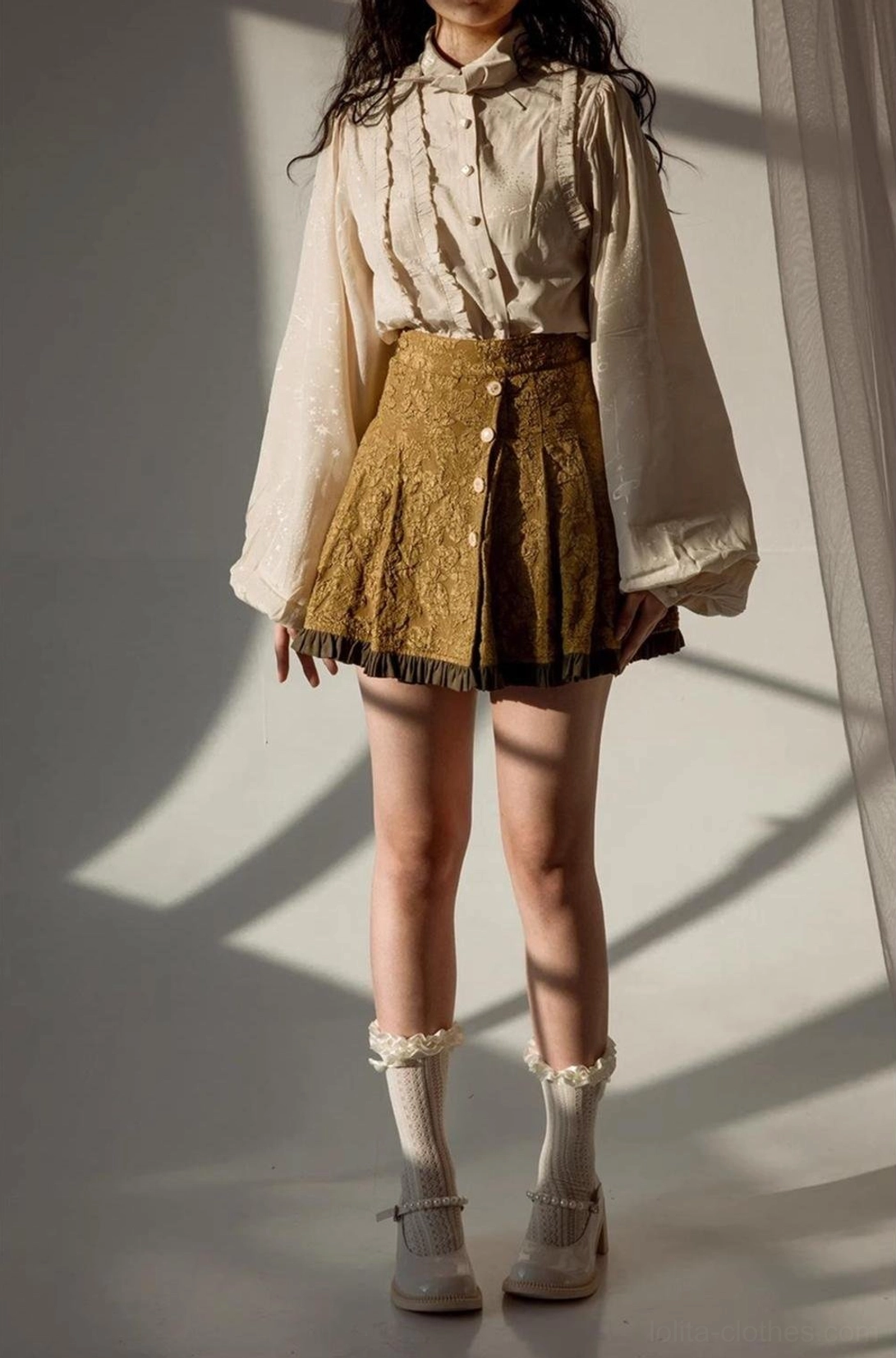 Beige Lolita blouse on model full body front studio shot worn with tan pleated high-waisted skirt and vintage Mary Jane shoes minimalist shadow lighting