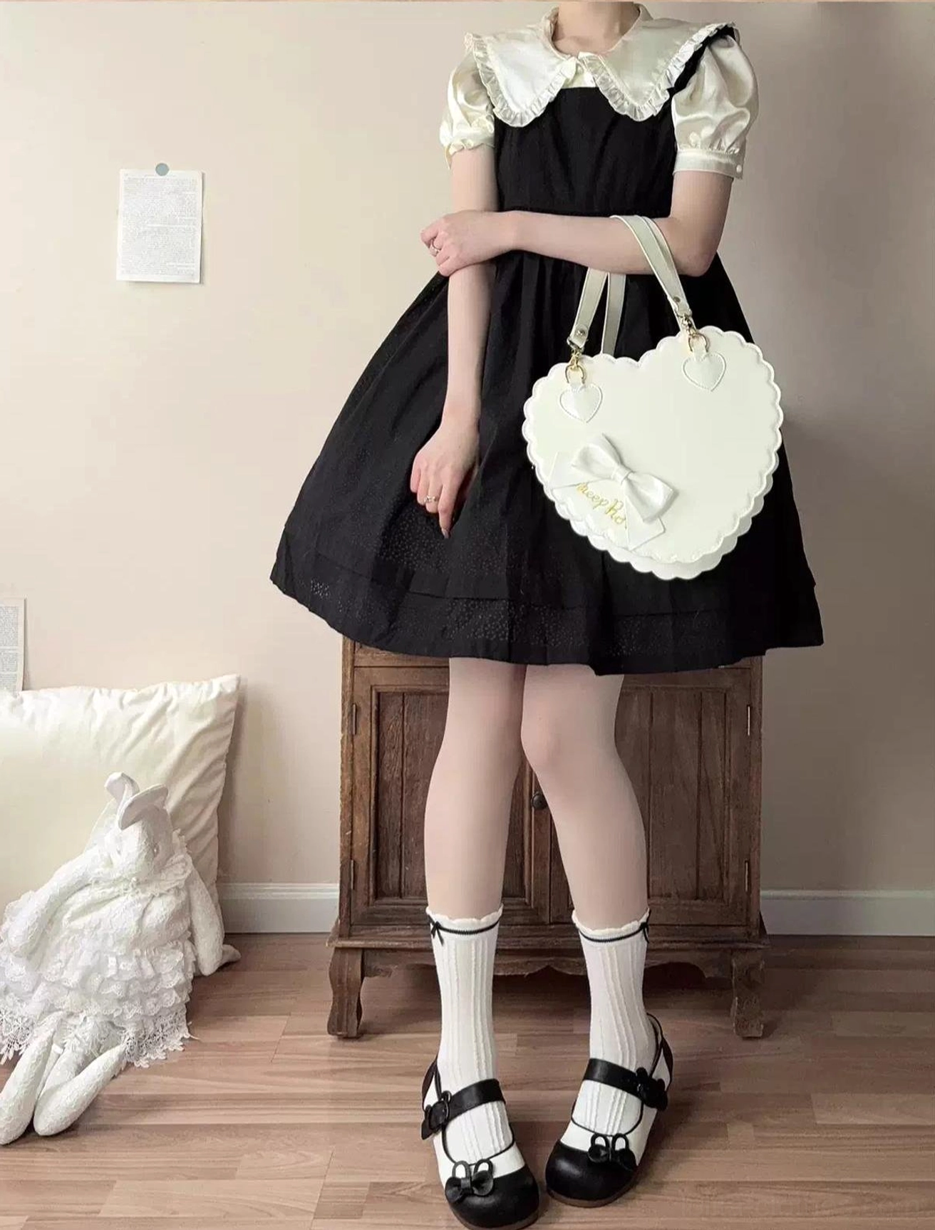 Beige and white two-tone lolita flat shoes worn with cream knit sweater and white socks leaning on vintage chair showing contrast color upper and bunny bow ankle strap