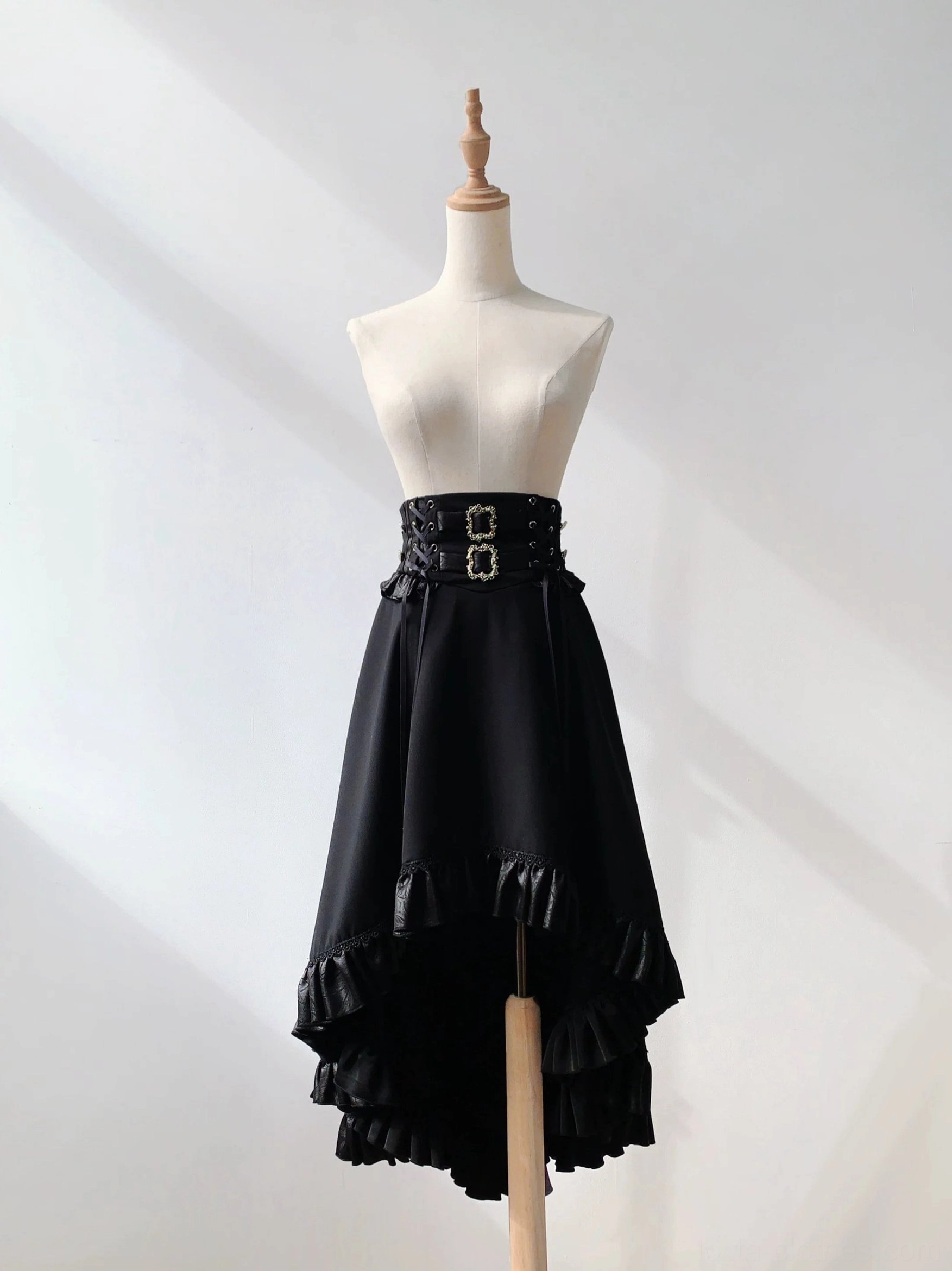 Black asymmetric A-line Ouji Lolita skirt hi-low ruffled hem double buckle leather waist belt front flat lay