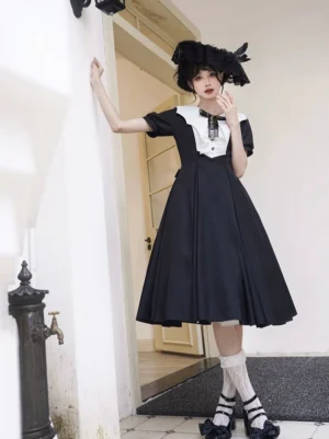 Black classic lolita OP dress with bat wing collar front standing pose featuring white sailor collar puff short sleeves pleated midi skirt model wearing formal hat outdoors