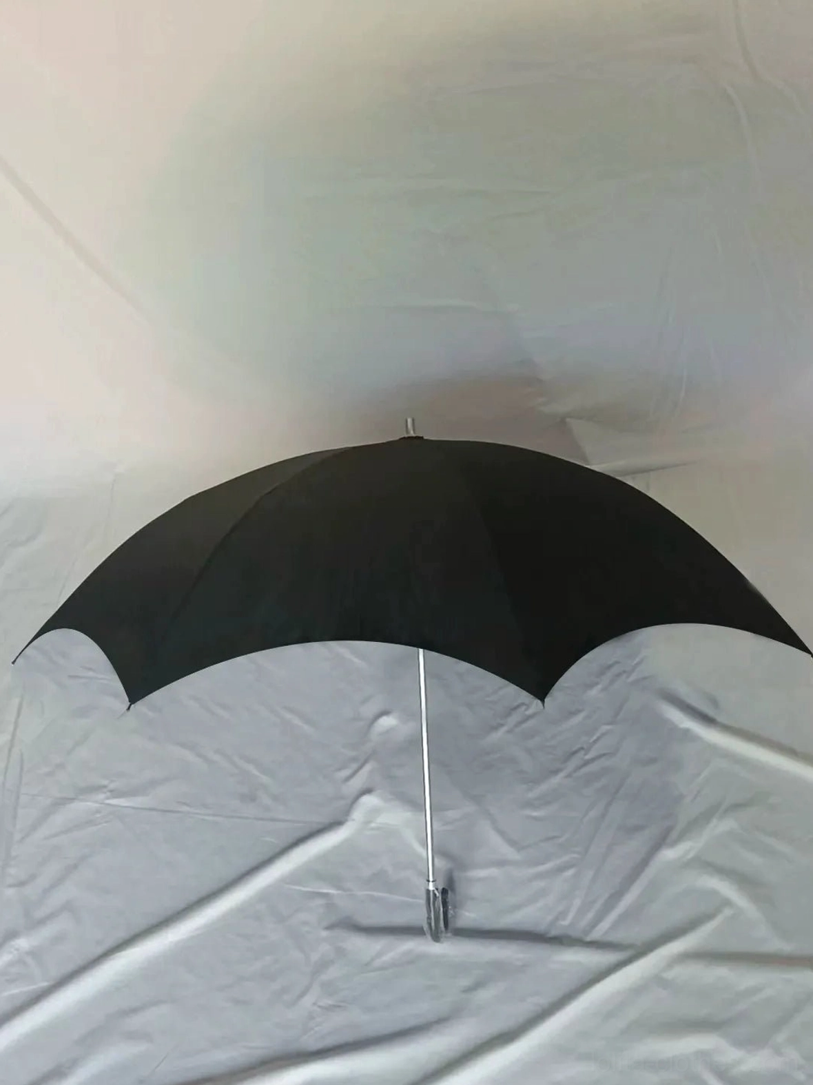Solid black bat-wing trim style straight-stick Lolita umbrella with curved ergonomic handle on white fabric background, front studio flat view