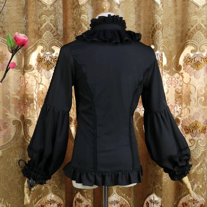Black classic Lolita blouse back view on dress form showing fitted waist, ruffled high neckline, adjustable bell sleeves with drawstring tightening, and layered hem with vintage floral backdrop