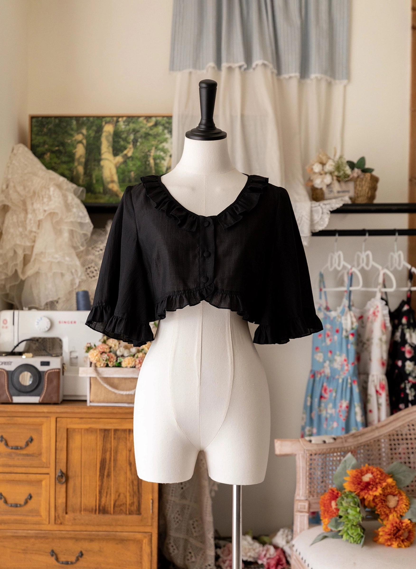 Black ruffled cropped cardigan front view on mannequin showing classic Lolita aesthetic, delicate flutter sleeves, button front closure, and sophisticated silhouette for any dress