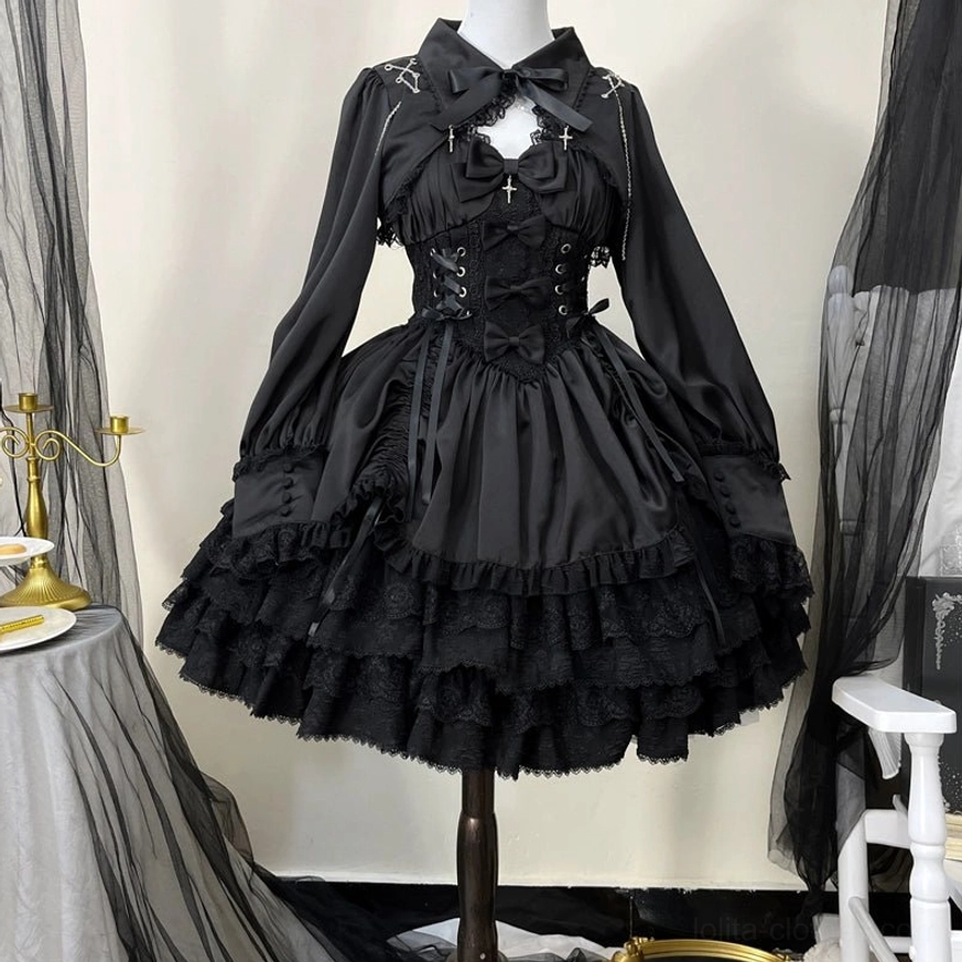 Black Cross Medal Gothic Lolita JSK dress with matching long-sleeve bolero, front view on dress form displaying lace-up corset waist, cross chest ornament, and multi-layered ruffled lace skirt